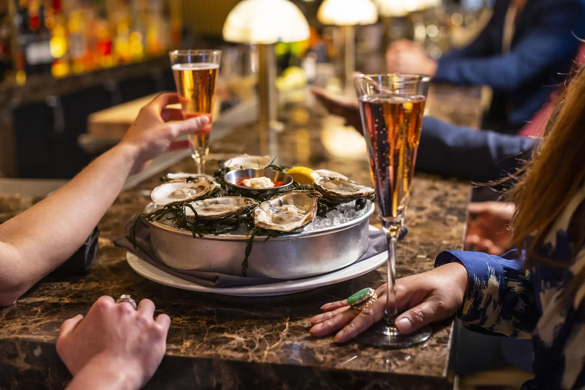 Ocean Prime diners enjoying Oysters and Champagne